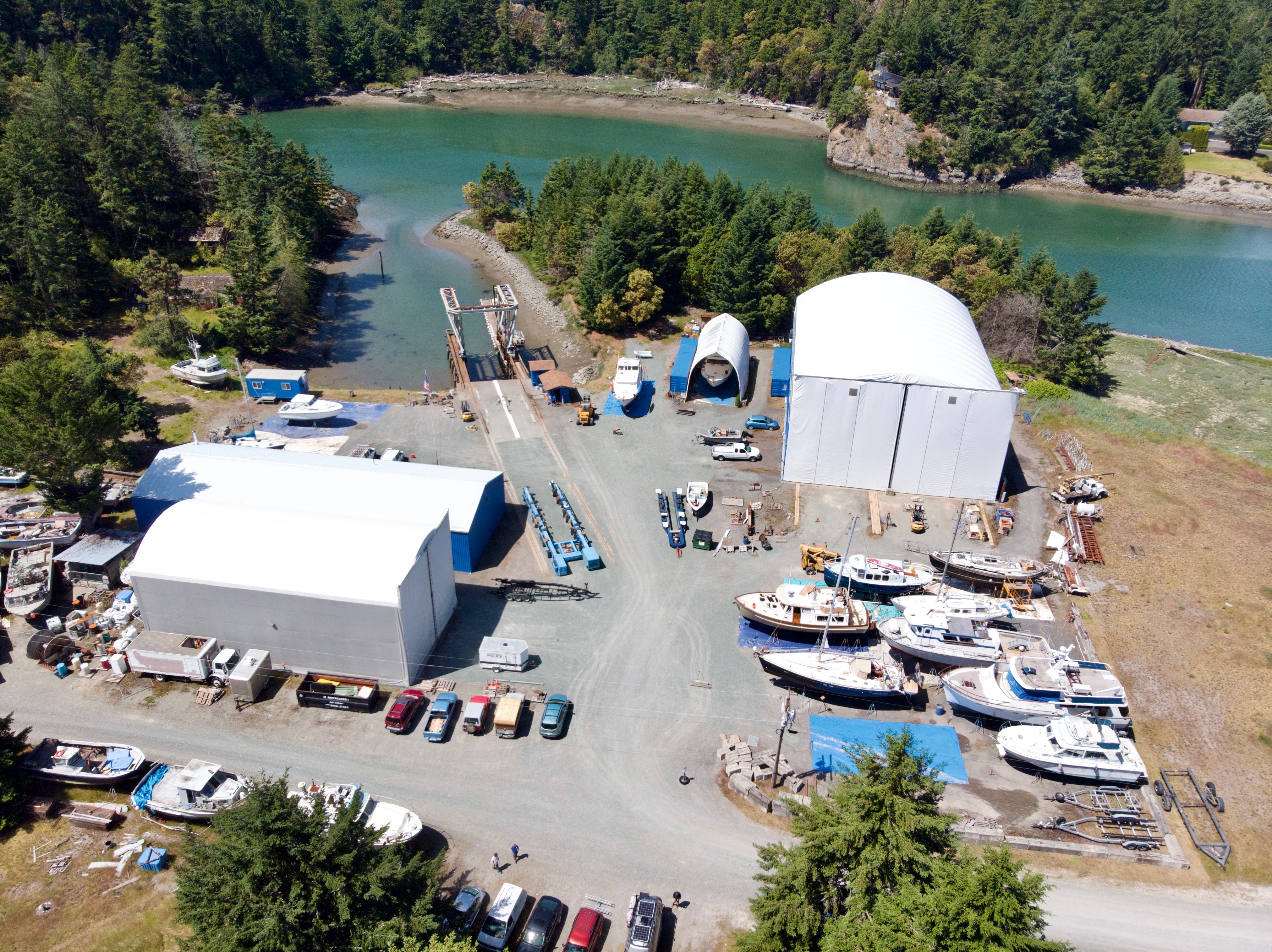 Aerial view of the Essential Shipyard yard at McGlinn Island, La Conner, Washington, with vessels blocked ashore