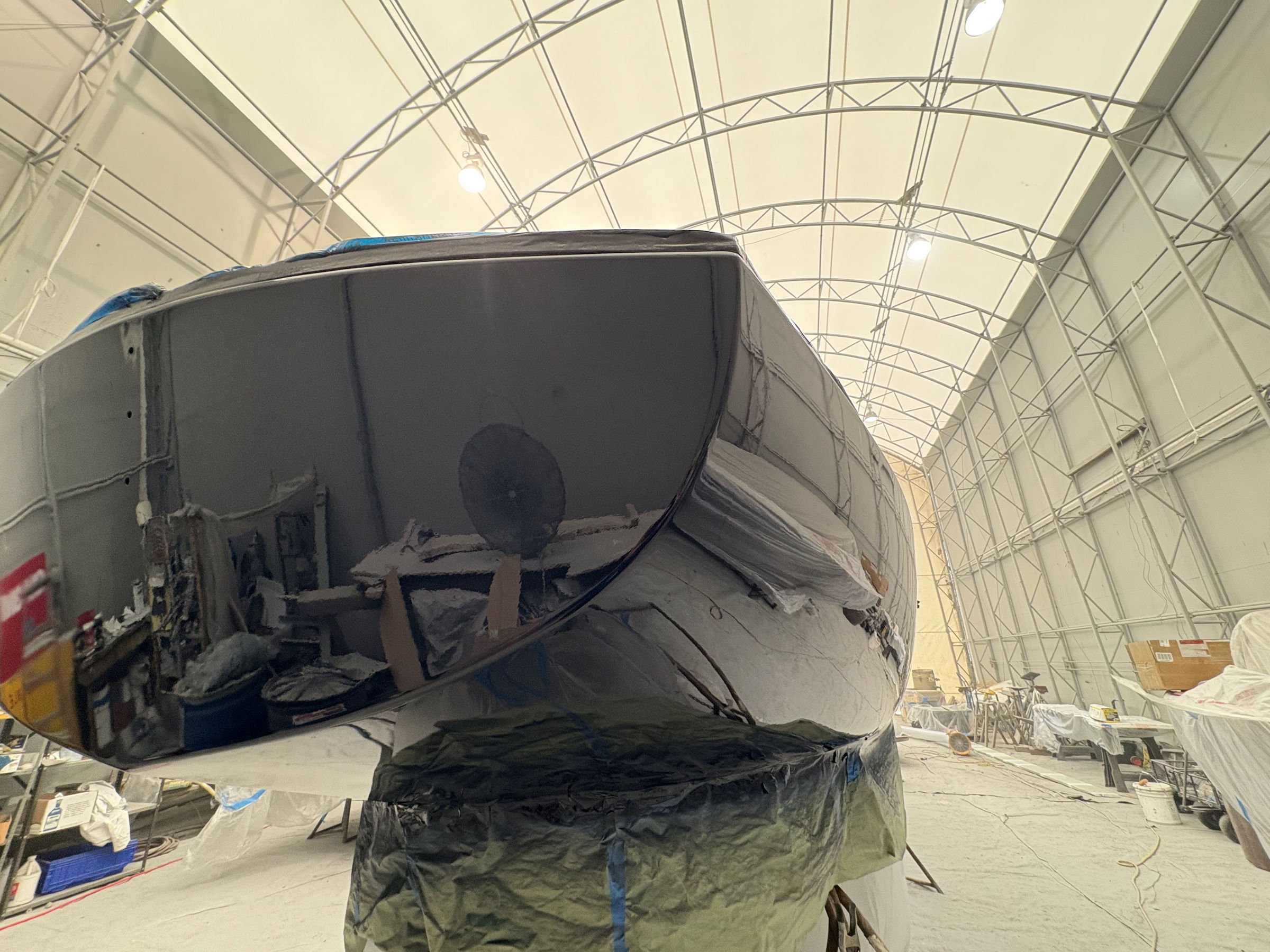 Sailboat bow faired and in primer ahead of refinishing at Essential Shipyard