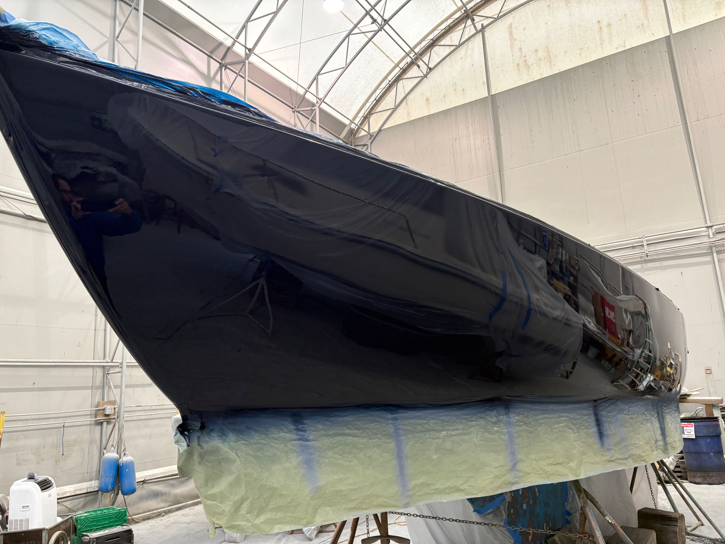 Deep gloss topside finish sprayed indoors on a sailboat at Essential Shipyard