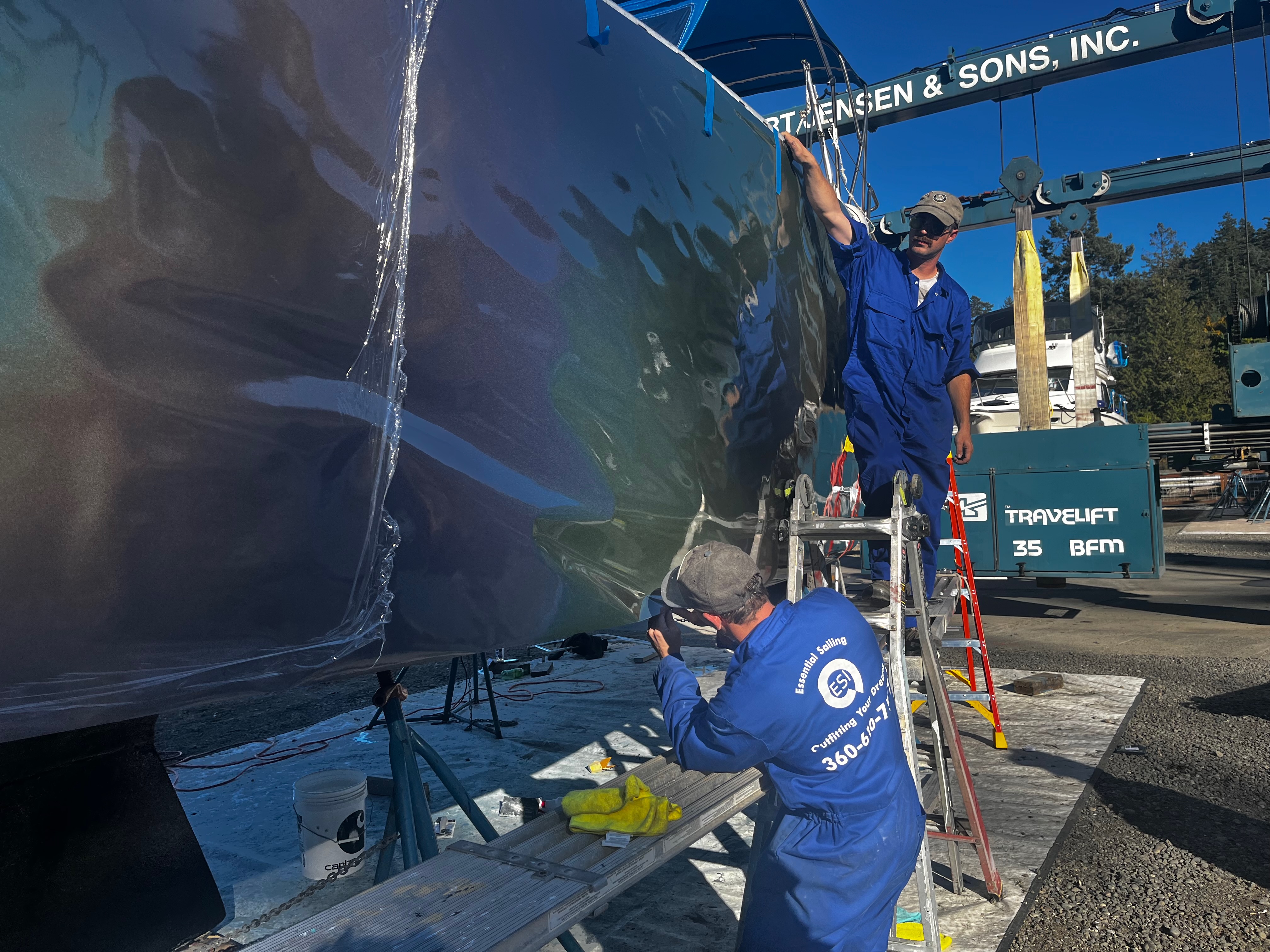 Essential Shipyard technician working on a hull beside the travel lift