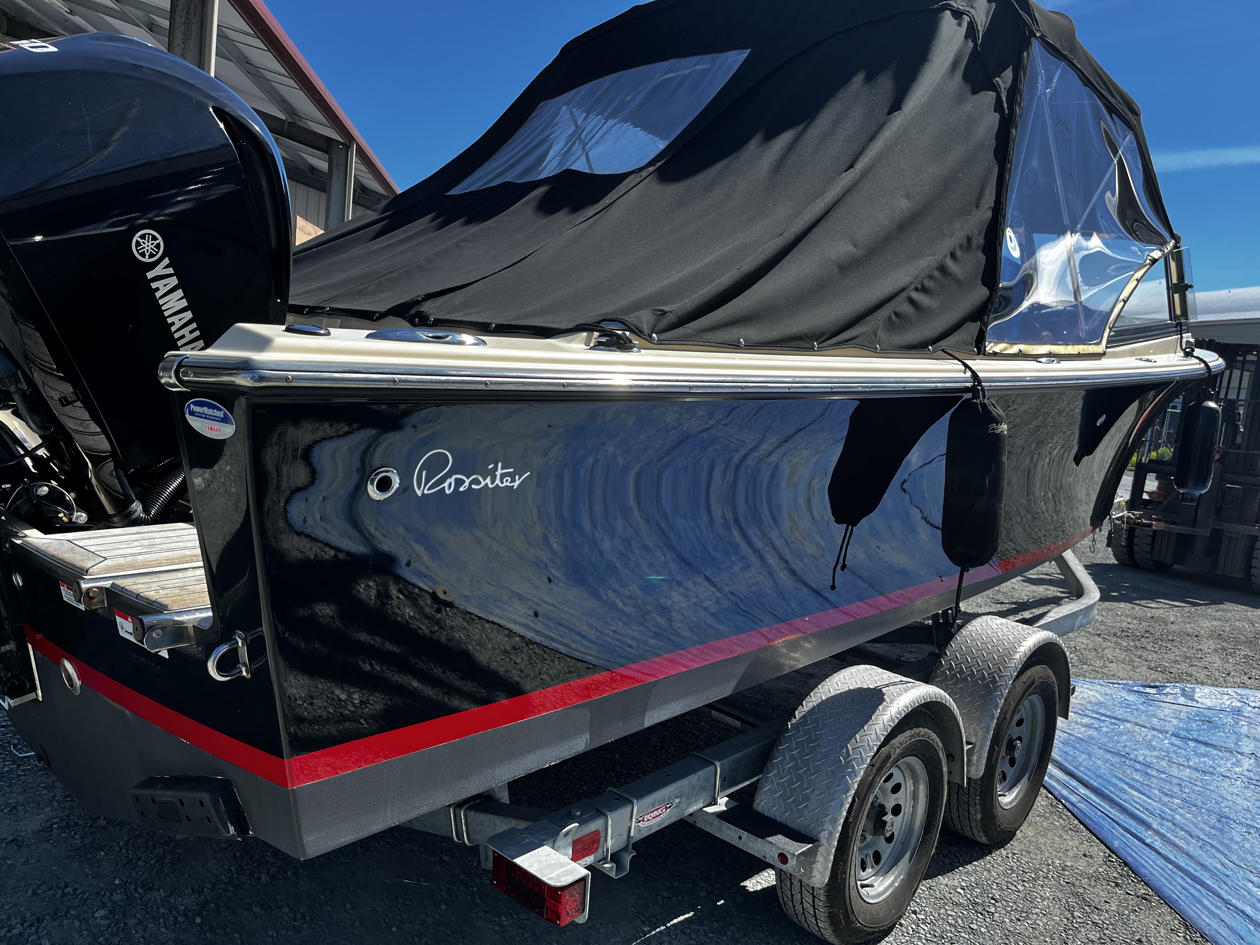 A dark blue Rossiter sport boat on its trailer after finishing work at Essential Shipyard