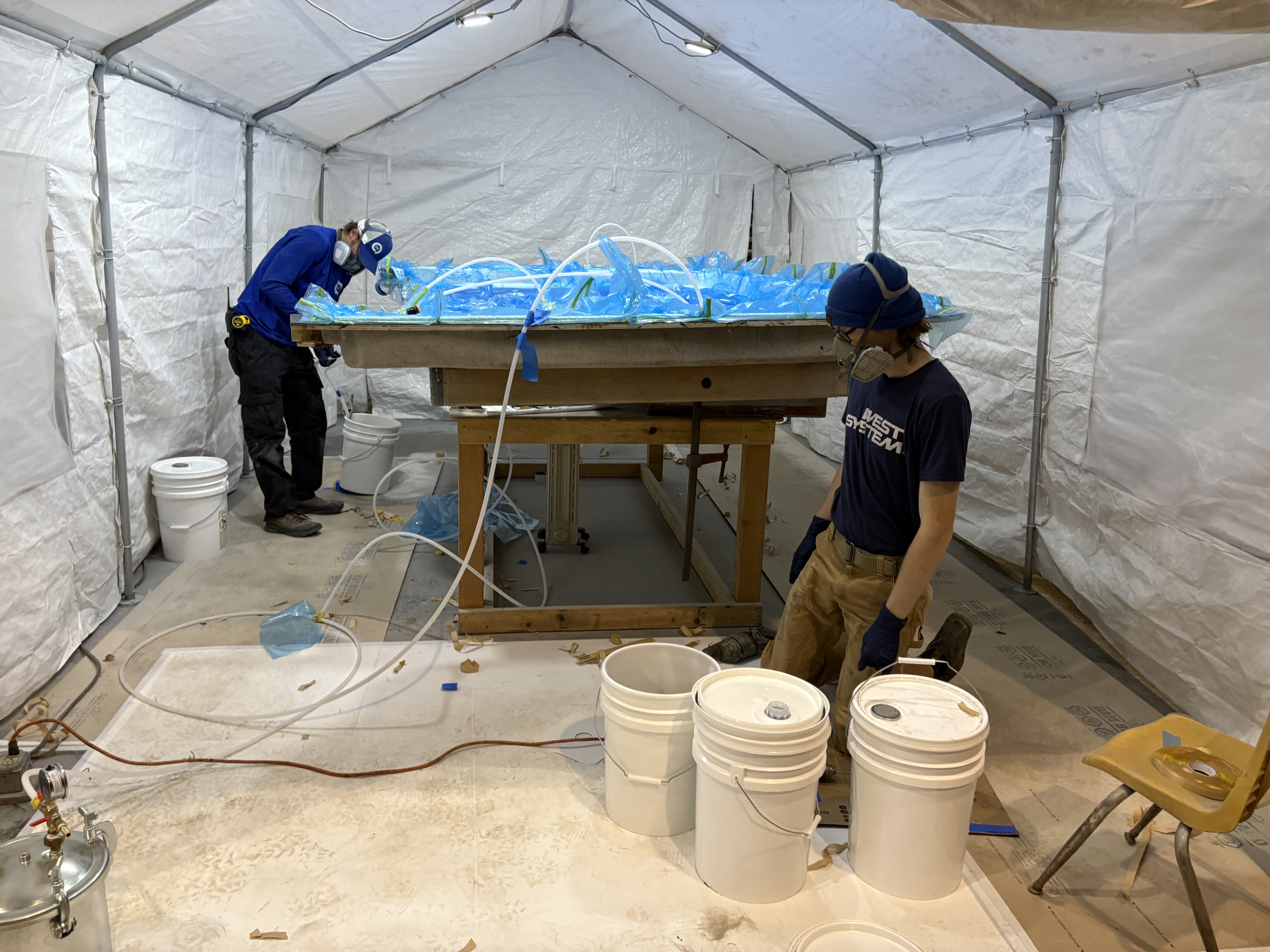 Laminating on the layup table in the covered bay, Essential Shipyard