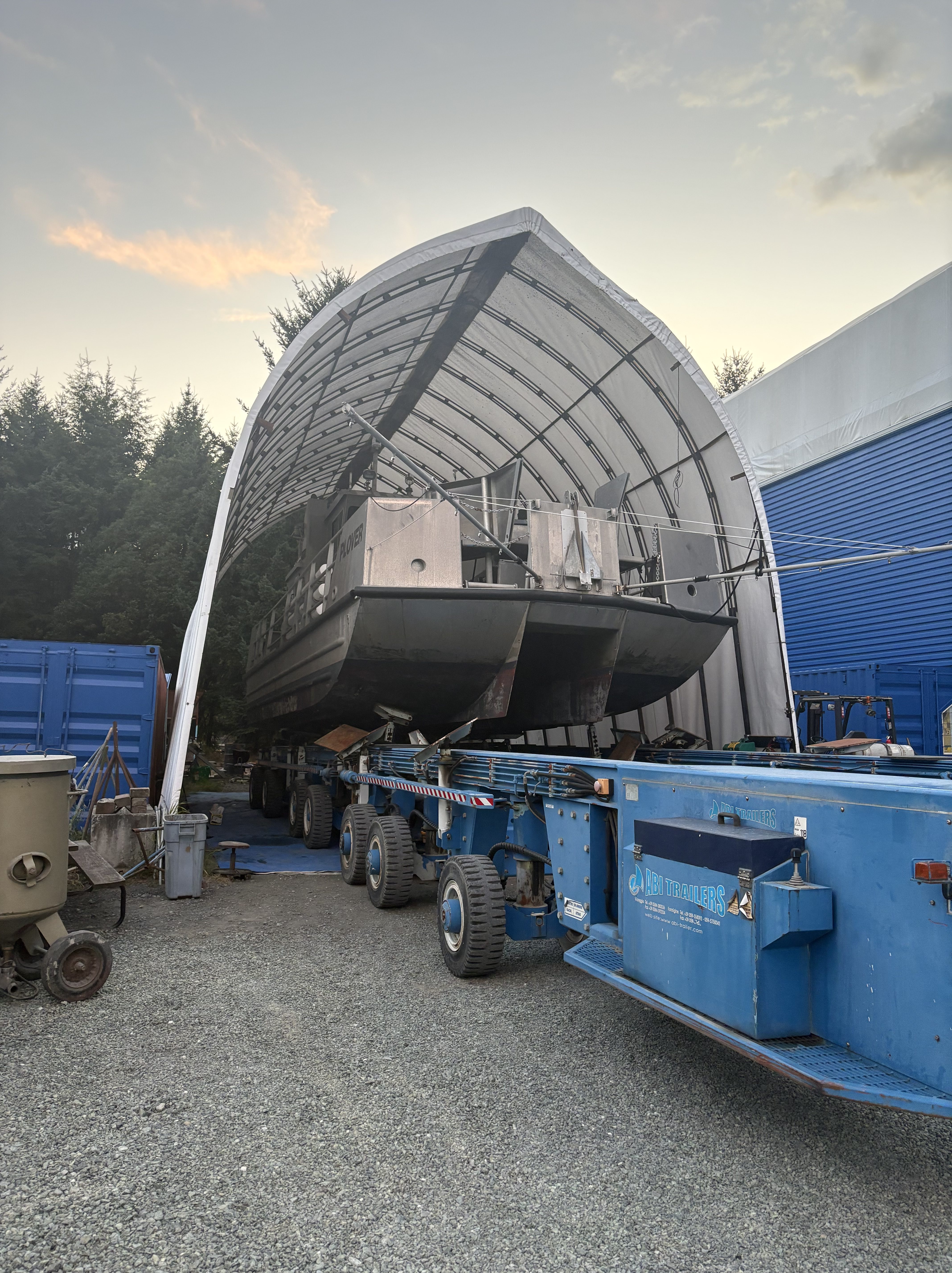 Large vessel loaded on the 200-ton hydraulic trailer at Essential Shipyard at sunset