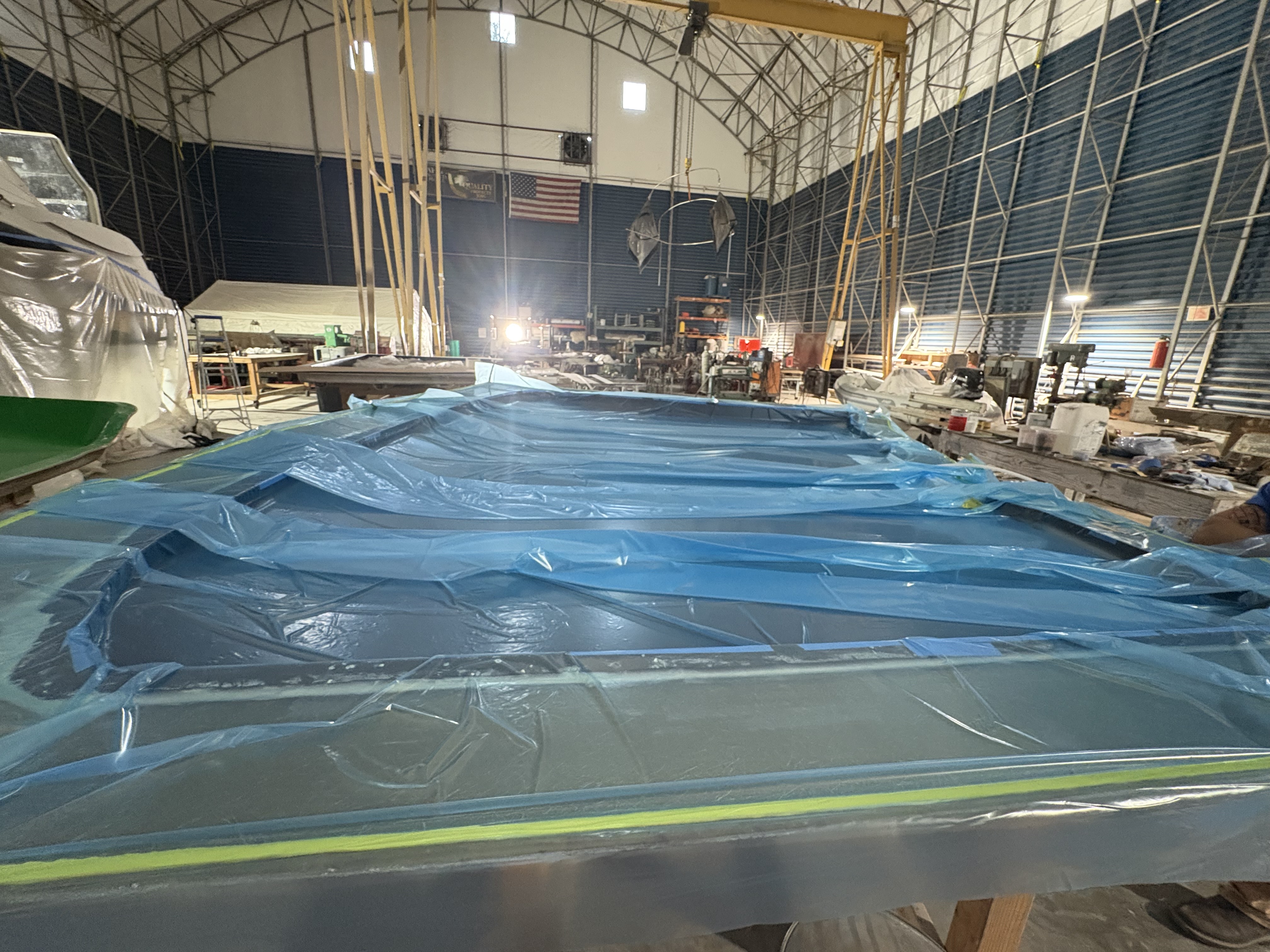 Vacuum bag pulled down over a hull in the build shed, Essential Shipyard