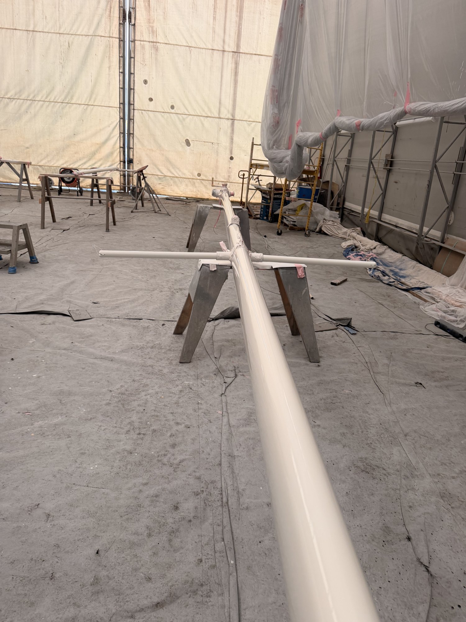 A mast repainted in Awlgrip, on trestles in the shop.