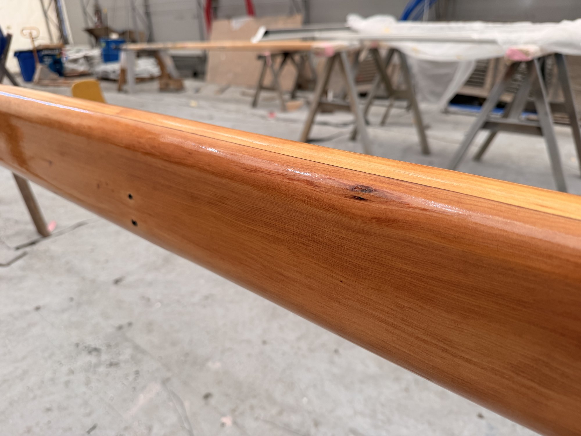 The finished spar, wood grain visible through the gloss.